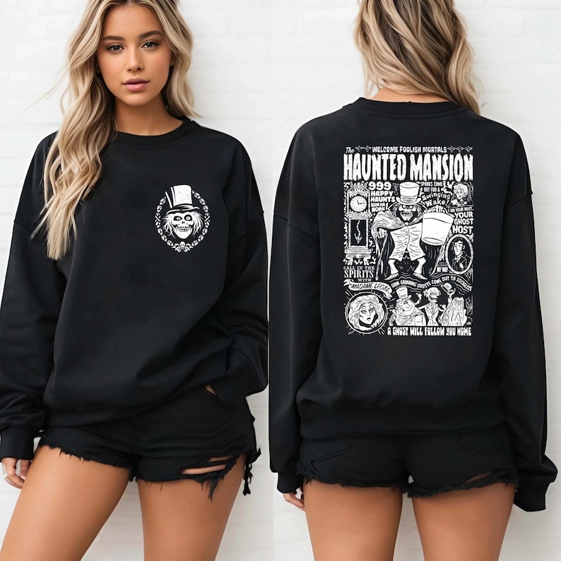 May include: Black sweatshirt with a white graphic print of a ghost and the text "Haunted Mansion" on the back. The front of the sweatshirt has a smaller graphic of a ghost with a top hat.