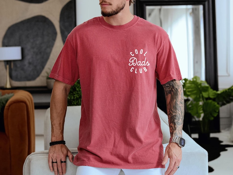 May include: A red t-shirt with a white graphic that says "Cool Dads Club" in a circle.
