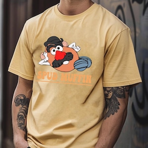 May include: A yellow t-shirt with a cartoon image of Mr. Potato Head wearing a hat and sunglasses. The text "SPUD MUFFIN" is printed below the image.