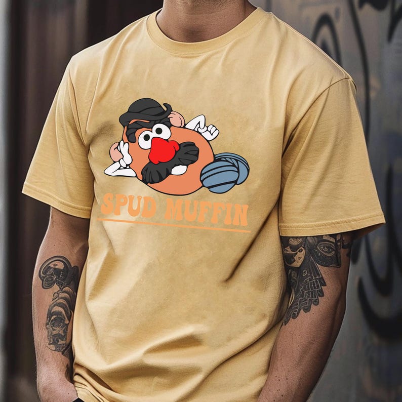 May include: A yellow t-shirt with a cartoon image of Mr. Potato Head wearing a hat and sunglasses. The text "SPUD MUFFIN" is printed below the image.