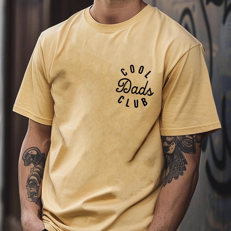 May include: A yellow t-shirt with a black graphic that says "Cool Dads Club" in a circle.