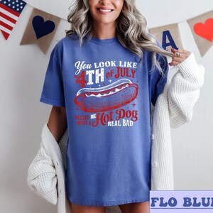 May include: A blue t-shirt with a red, white, and blue graphic that says "You look like the 4th of July. Makes me want a hot dog real bad."