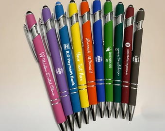 May include: A collection of colorful pens with silver accents. Each pen has a different color barrel, including pink, purple, blue, yellow, orange, green, and burgundy. Some pens have text, including "Wisdom Dental Clinic", "R.G Payment Bank", and "Hannah M. Donald".