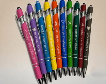 May include: A collection of ten colorful ballpoint pens with stylus tips, each featuring a unique engraved message and icon. The pens are arranged in a fan shape, displaying colors including pink, purple, blue, yellow, orange, green, and dark gray.