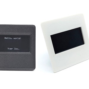 May include: Two black plastic slide mounts, one with a black screen displaying the text "Hello, world!" and "Yuer Inc.", and the other with a blank black screen.
