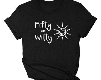 May include: Black t-shirt with the words "Fifty and Witty" in white script, accompanied by a white sun graphic. The shirt is knotted at the bottom. The brand name "SUNANDSALTDESIGNS" is printed at the bottom.
