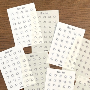 May include: Nine sheets of white paper with black weather icons printed on them. Each sheet has the text "MICRO ICON" printed in the top left corner. The icons include clouds, sun, rain, and wind.