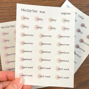 Op de afbeelding: Drie vellen plannerstickers met de tekst "today", "tomorrow", "weekend" en "next week" in handschrift. De stickers zijn nude-kleurige stippen. De tekst "Mini Dot Text Nude" staat bovenaan het vel.