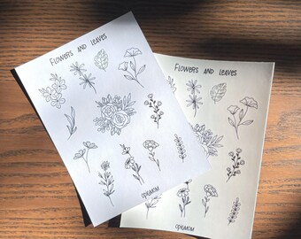 May include: Two sheets of white paper with black line drawings of flowers and leaves. The text "Flowers and Leaves" is printed at the top of each sheet. The text "Origami" is printed at the bottom of each sheet.