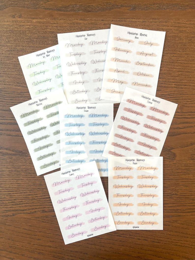 May include: Nine sheets of stickers with handwritten days of the week and months of the year. Each sheet has a different color theme, including green, blue, pink, and brown.
