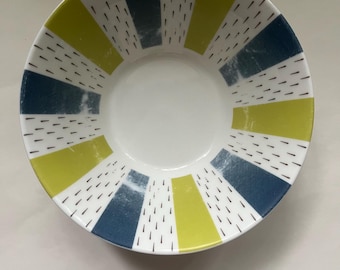 May include: A white ceramic bowl with a blue and yellow striped pattern. The stripes are accented with small black dashes.