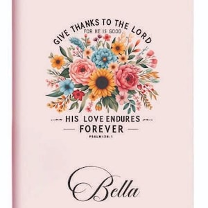 May include: A pink notebook featuring a floral design and the text "GIVE THANKS TO THE LORD FOR HE IS GOOD. HIS LOVE ENDURES FOREVER" and "Bella". The floral design includes sunflowers, roses, and other colorful flowers.