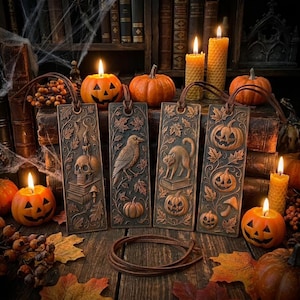 Könnte beinhalten: Eine Sammlung von Halloween-Lesezeichen mit geprägten Designs von Totenkopf, Rabe, Katze und Kürbissen. Die braunen Lesezeichen haben Lederbänder und sind von Kürbissen, Kerzen und Herbstblättern umgeben.