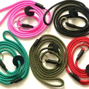 May include: Five dog leads in different colours: pink, green, black, red, and olive green. Each lead has a black ring and a black clip.