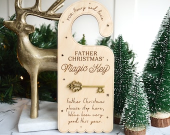 May include: A wooden door hanger with the text "FATHER CHRISTMAS' Magic Key" and a decorative key. The hanger is light brown with a scalloped edge and includes the text "FOR: Henry and Rosie".