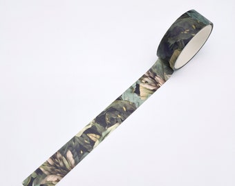May include: A roll of adhesive tape featuring a dark botanical pattern with deep green leaves and muted beige floral elements. The tape is partially unrolled, displaying a continuous print of overlapping foliage and petals on a matte surface.