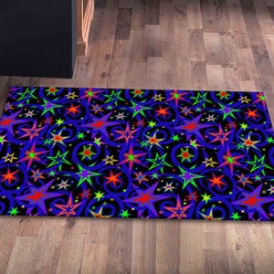 May include: A blue rug with a repeating pattern of colorful stars and swirls. The stars are in shades of red, yellow, green, and purple.
