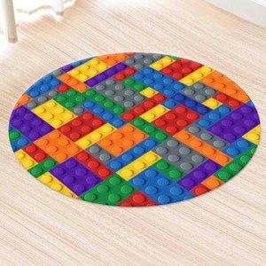 Puede incluir: Una alfombra redonda con un diseño colorido de bloques de construcción entrelazados. La alfombra está hecha de un material suave y duradero y es perfecta para agregar un toque lúdico a cualquier habitación.