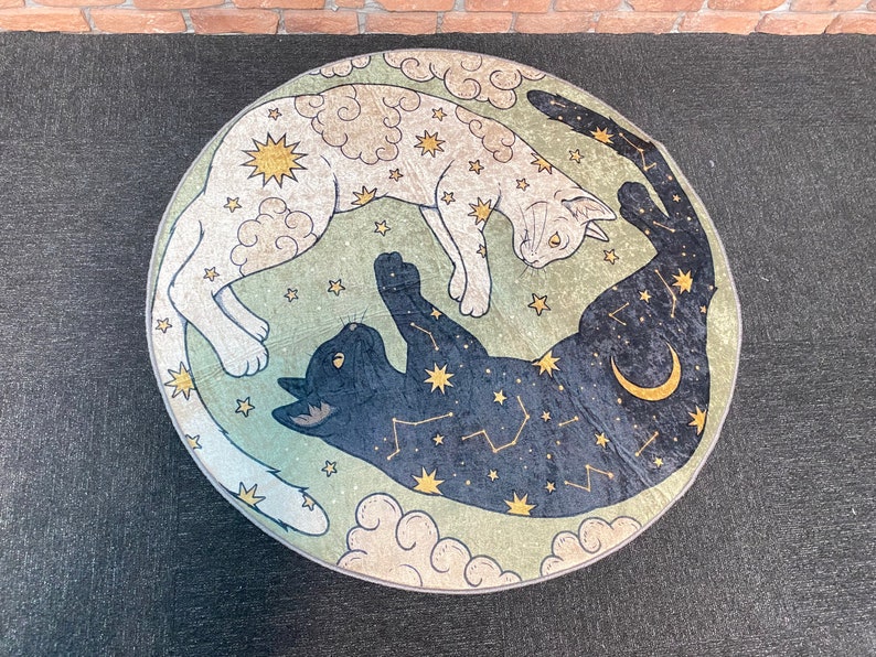 May include: A round green and white rug with a black and white cat and a white cat with black spots. The cats are depicted in a yin yang style with stars and clouds.