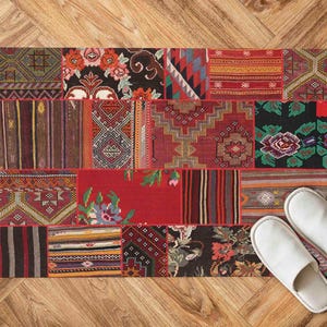 May include: A rectangular patchwork rug with a variety of patterns and colors, including red, black, and floral designs. Two white slippers are placed on the wooden floor next to the rug.