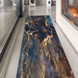 May include: A blue and gold abstract area rug with a marble-like pattern. The rug has a modern design and would add a touch of elegance to any room.