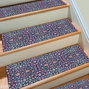 Peut inclure: Ensemble de trois marches d'escalier antidérapantes avec un motif floral dans les tons de rose, vert et bleu sur un fond bleu foncé.
