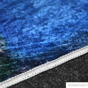 May include: Close-up of a blue and green non-woven thin rug with a white stitched edge.