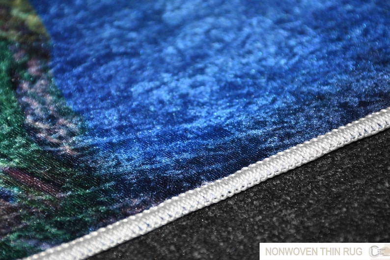 May include: Close-up of a blue and green non-woven thin rug with a white stitched edge.