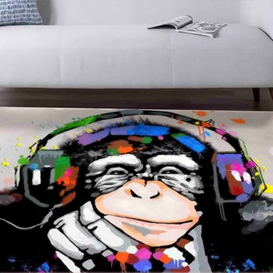 Può includere: Un dipinto astratto colorato di una scimmia con le cuffie. La scimmia è dipinta in tonalità di nero, bianco e marrone, con schizzi di colore in tutto il dipinto. Le cuffie sono dipinte in una varietà di colori, tra cui rosso, blu, verde e giallo.