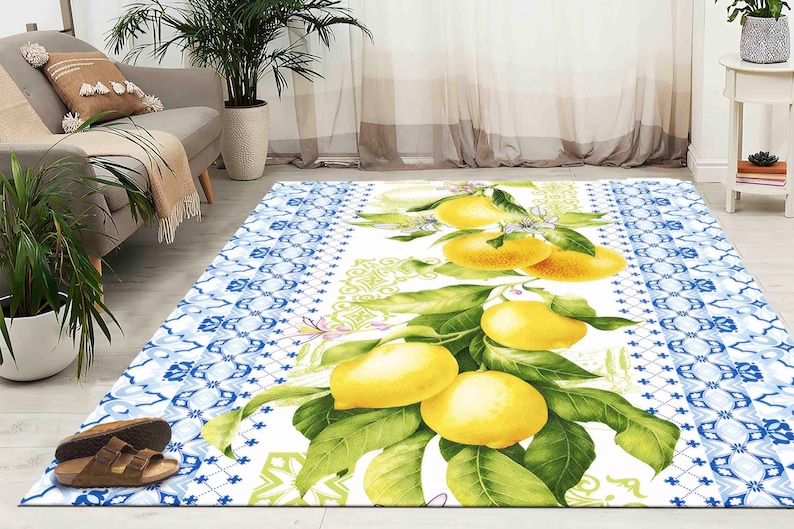 May include: A white and blue patterned rug with a lemon tree design. The rug features yellow lemons, green leaves, and white flowers. The rug has a blue and white border.