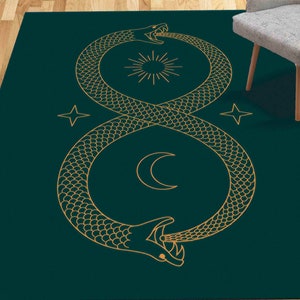May include: A dark green rug with a gold outline of two snakes forming an infinity symbol. The snakes are intertwined and have scales. The center of the infinity symbol features a sun and a crescent moon.
