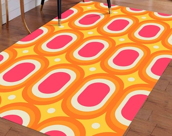 May include: A yellow, orange, and pink patterned rug with a repeating geometric design. The rug has a retro, 70s style.
