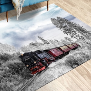 Può includere: Tappeto rettangolare con un treno a vapore nero e rosso che attraversa una scena di foresta in bianco e nero. Il tappeto presenta un'immagine dettagliata del treno sui binari, con uno sfondo di cielo nuvoloso.