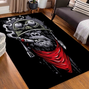 Può includere: Un'illustrazione in bianco e nero di un gorilla che indossa un elmetto militare e una bandana rossa. Il gorilla fuma un sigaro e ha un'espressione seria sul viso.