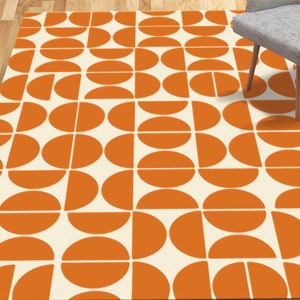 May include: A white and orange geometric area rug with a repeating pattern of half circles and circles. The rug has a modern, mid-century design.