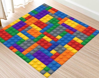 Pode incluir: Um tapete colorido com um padrão de quadrados interligados que se assemelham a blocos de construção de brinquedos. O tapete apresenta tons de vermelho, amarelo, azul, verde, roxo e cinza.