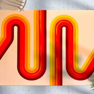 May include: Abstract art print featuring a retro design with curved, layered lines in shades of red, orange, and yellow against a light peach background. The artwork has a vintage aesthetic, reminiscent of the 1970s. The print is displayed on a wall.