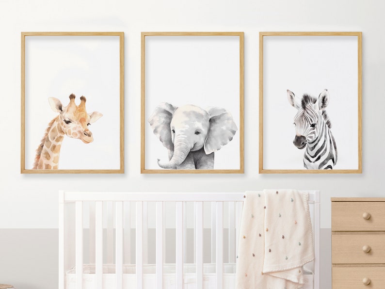 May include: Three framed watercolor paintings of animals. The first painting features a giraffe with a light brown and orange coat. The second painting features a gray elephant with a trunk. The third painting features a zebra with black and white stripes.