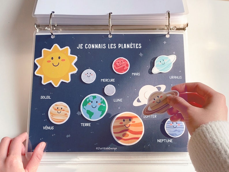 Op de afbeelding: Een kleurrijk educatief bord met de titel "Je connais les plan&egrave;tes" (Ik ken de planeten) met een gele zon met een lachend gezicht en illustraties van de planeten in ons zonnestelsel, waaronder Mercurius, Venus, Aarde, Mars, Jupiter, Saturnus, Uranus en Neptunus.