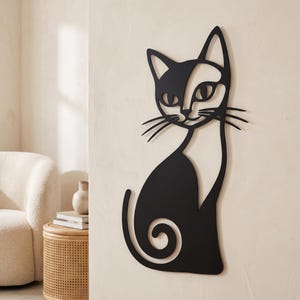 Pode incluir: Uma peça de arte de parede em metal preto com o formato de um gato estilizado. O design apresenta um gato sentado com a cauda enrolada, orelhas pontiagudas e bigodes longos. A silhueta é criada com linhas contínuas, formando uma figura plana.
