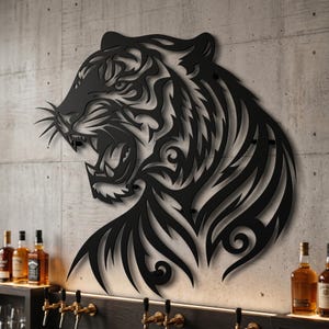 Puede incluir: Una pieza de arte mural de metal negro con un diseño recortado estilizado e intrincado de una cabeza de tigre de perfil, con la boca abierta, dientes afilados y líneas curvas fluidas que forman los rasgos faciales y el pelaje.