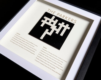 May include: A framed black and white crossword puzzle with the title "The Parkers" and clues listed below. The crossword puzzle features names like "Chloe", "Nina", "David", and "Ava".