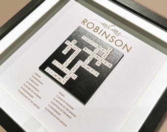 May include: A black and white wedding crossword puzzle with the names "Mr. & Mrs. Robinson" at the top. The crossword puzzle is framed in a black frame with a white mat. The clues for the crossword puzzle are listed below the puzzle.