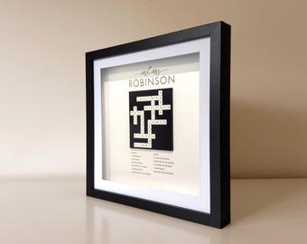 May include: A black framed picture with a white mat. The picture contains a crossword puzzle with the names "LUCINDA" and "RICHARD" and the last name "ROBINSON".