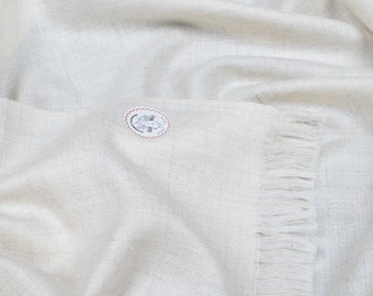 May include: A white pashmina shawl with a fringed border. The shawl is made from soft, luxurious cashmere and is ideal for keeping warm on chilly days.