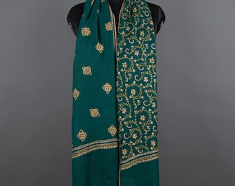 May include: A teal green shawl with gold embroidery. The shawl has a floral pattern on one side and a geometric pattern on the other side.