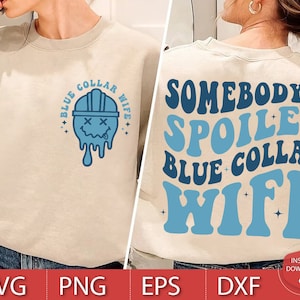 May include: A beige sweatshirt with a blue graphic of a cartoon construction worker with the text "Blue Collar Wife" above and below the image. The same text is on the back of the sweatshirt in a blue retro font with the text "Somebody's Spoiled" above it.