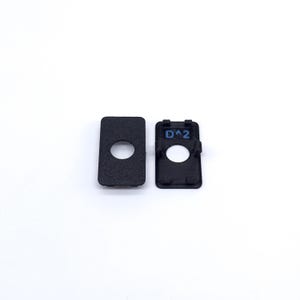 May include: Two black plastic pieces with a round hole in the center. One piece has the text "D^2" printed on it.