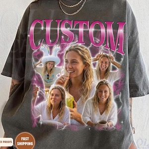 Puede incluir: Una camiseta gris carbón de corte oversize con la palabra CUSTOM en letras rosas grandes en la parte superior. El gráfico incluye tres retratos fotográficos de una persona con cabello rubio largo sobre un fondo de rayos y humo rosa.