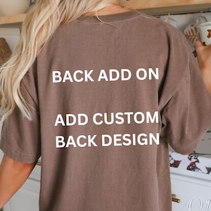 Może przedstawiać: T-shirt w kolorze espresso z białym napisem "BACK ADD ON, ADD CUSTOM BACK DESIGN". Koszulka ma neutralny brązowy kolor. Tekst "OLD SCHOOL CULT" jest widoczny w prawym dolnym rogu.